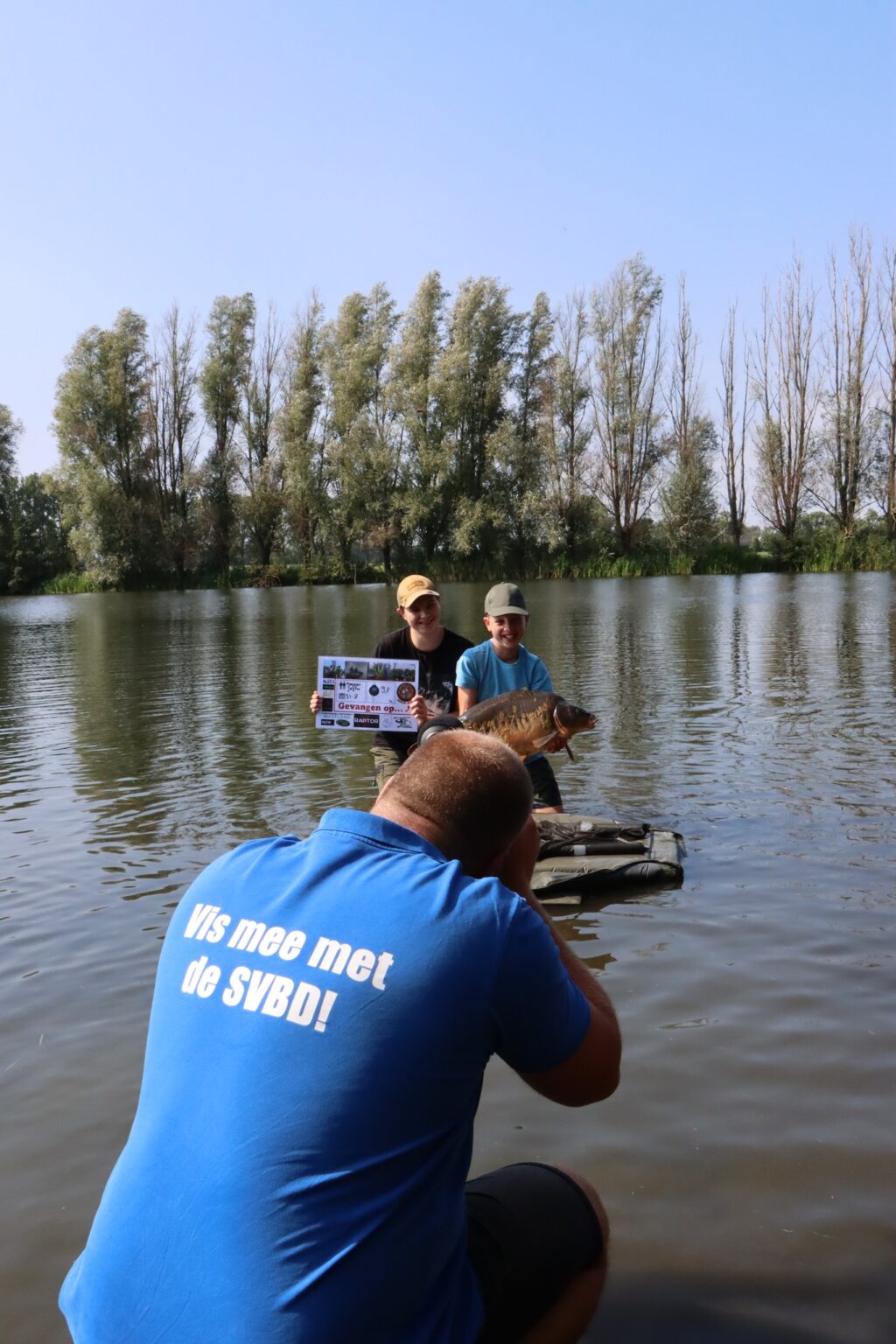 Kan een afbeelding zijn van 3 mensen, vissende mensen, waterpartij en tekst